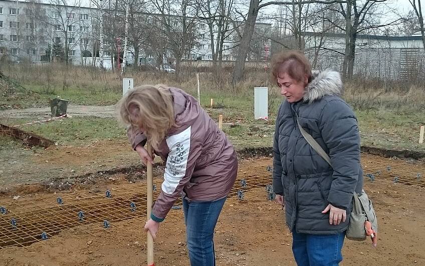 Bauherrin und Tochter beim Graben des Grundsteinloches
