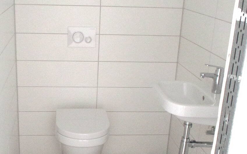 Toilette und Waschbecken wurden im Gäste-WC bereits befestigt.