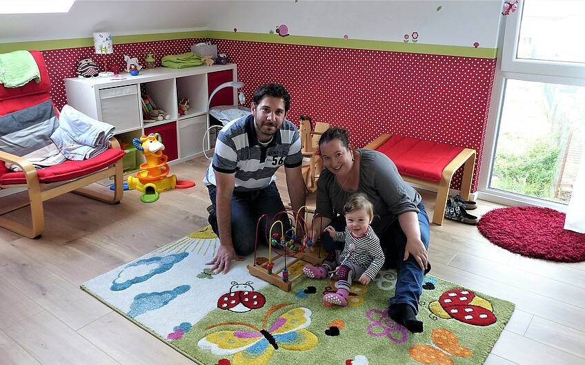 Bauherren mit Tochter im Kinderzimmer des Familienhauses Komfort in Linkenheim-Hochstetten