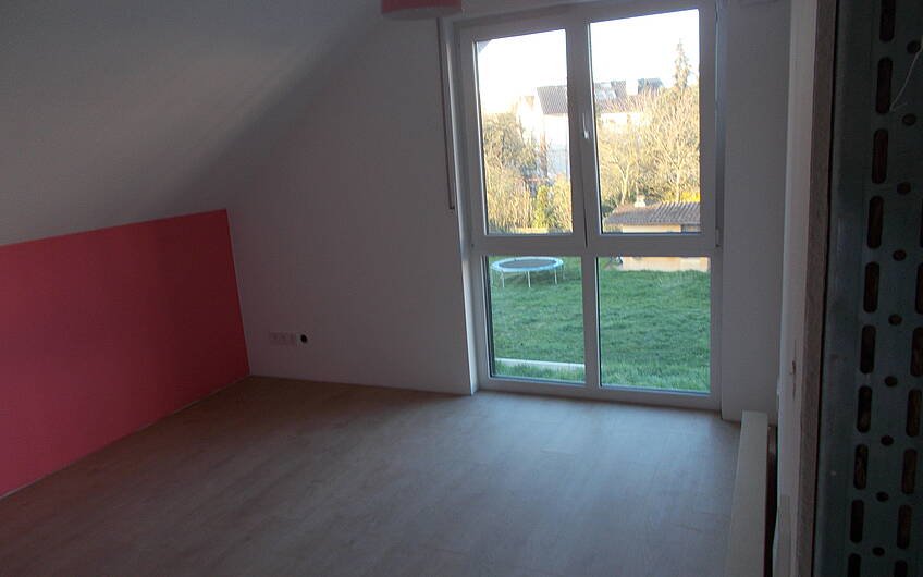 Zimmer im Dachgeschoss des frei geplanten Einfamilienhauses von Kern-Haus in Frankenthal mit fertigem Boden und gestrichener Wand