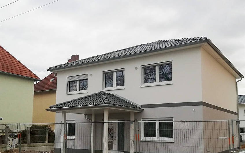 kern-Haus Stadtvilla Signus mit Vordach und hellgrauem Außenputz in Halle Ammendorf