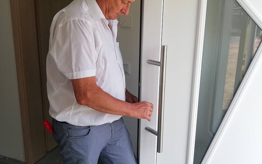 Bauleiter wechselt Türschloss an Haustür des Kern-Haus Bungalow in Halle Ammendorf