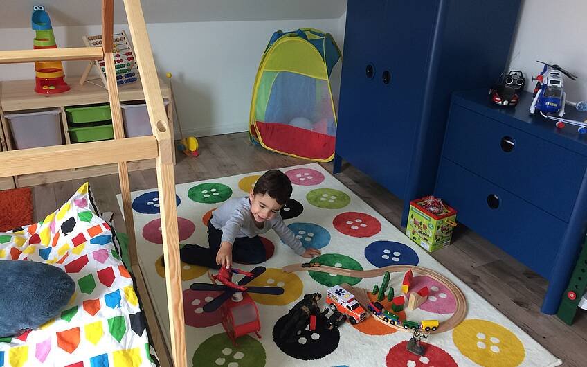 Sohn beim Spielen im Kinderzimmer im Einfamilienhaus Komfort von Kern-Haus in Neupotz