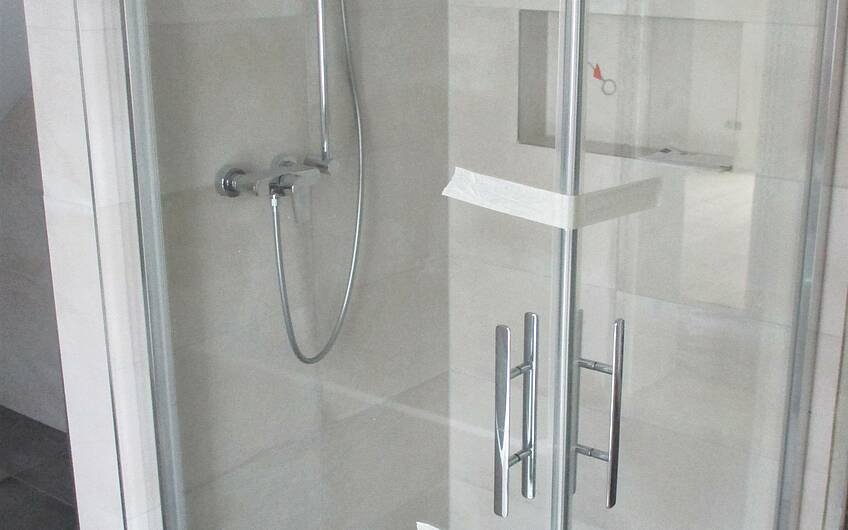 Maßgeschneidert erfolgte der Einbau der Eckverglasung in der Dusche.