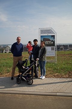 Bauherren vor Bauschild mit dem Kern-Haus Luna Baugebiet Erfurt-Marbach