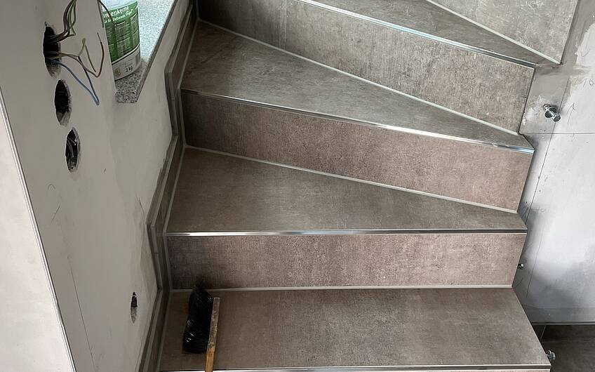 Fliesenabschlussprofile schützen die Kanten der gefliesten Treppe.