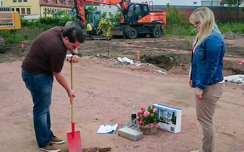Bauherr gräbt Loch für Grundsteinkassette bei Grundsteinlegung
