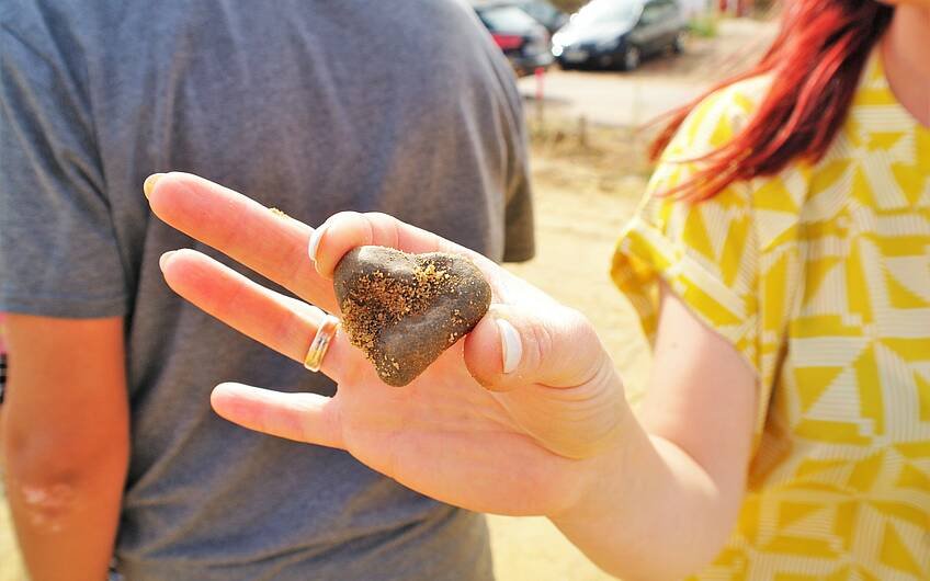 Herzförmiger Stein in der Hand einer Kern-Haus-Bauherrin in der Börde