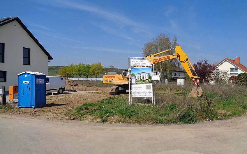 Bagger für die Erdarbeiten auf dem Grundstück für die individuell geplante Kern-Haus-Stadtvilla Signus in Flörsheim-Dalsheim
