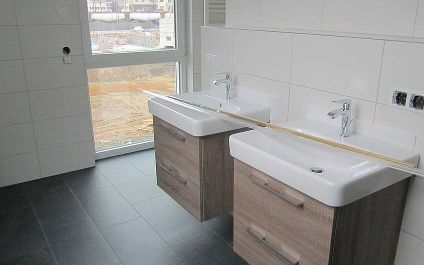 Zwei moderne Waschbecken mit passenden Unterschränken wurden im Bad montiert.