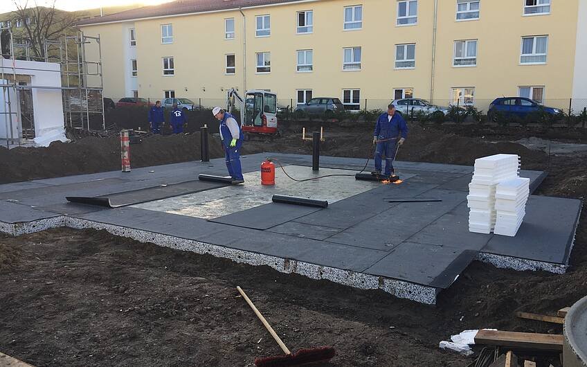 Arbeiter dichten Bodenplatte für ein Kern-Haus in Magdeburg ab