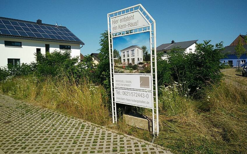 Aufgestelltes Bauschild auf dem Grundstück für die Kern-Haus-Stadtvilla Signus in Dettenheim-Rußheim