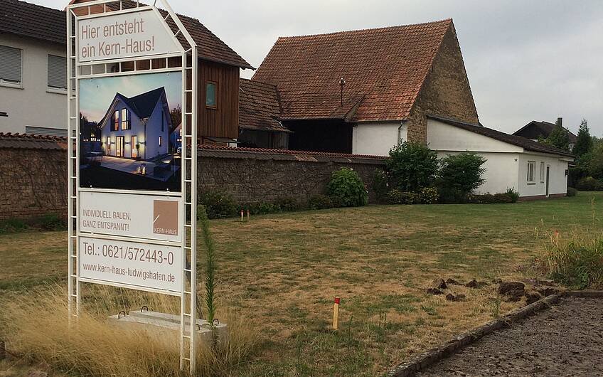 Bauschild auf dem Grundstück für das individuell geplante Einfamilienhaus Komfort von Kern-Haus in Herxheim