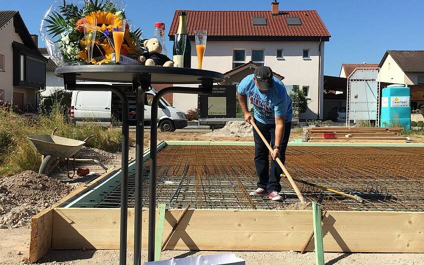 Bauherr mit Schaufel bei der Grundsteinlegung für das individuell geplante Einfamilienhaus Komfort von Kern-Haus in Neupotz