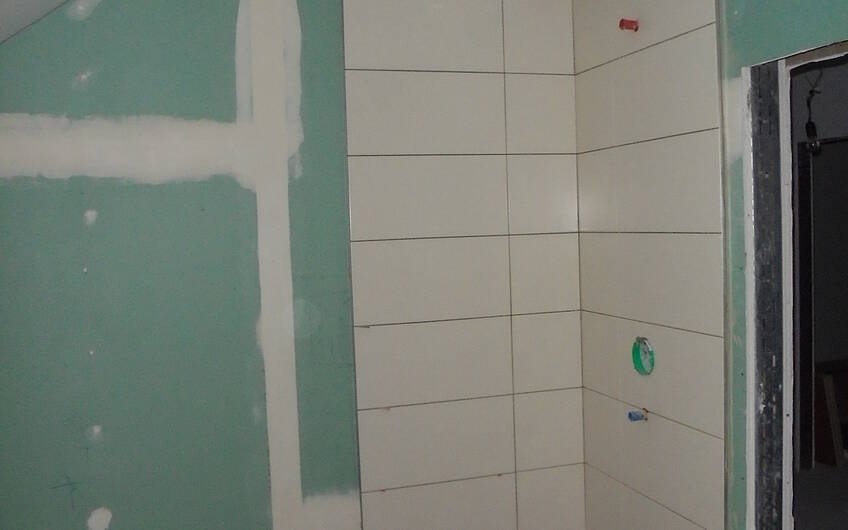 Fliesenarbeiten an der Dusche im Badezimmer des individuellen Kern-Hauses Komfort in Obrigheim