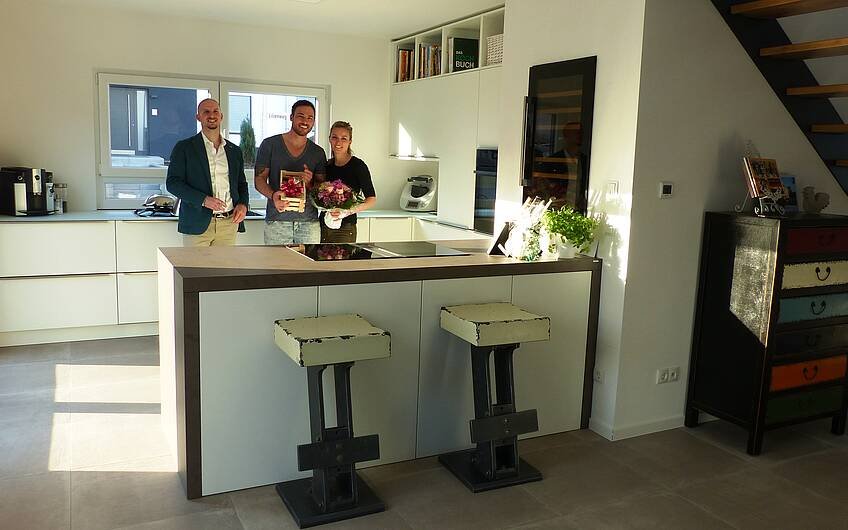 Bauherrenpaar mit Verkaufsberater Bernd Laatz in der Küche der Kern-Haus-Stadtvilla Signus in Otterberg