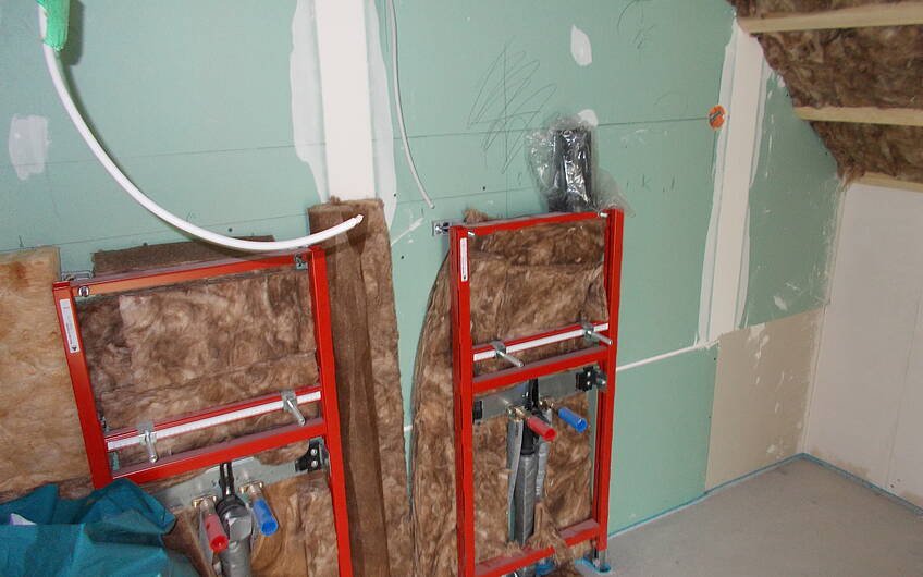 Dämmwolle hinter der Sanitärrohinstallation im Badezimmer im Kern-Haus Signum in Einselthum