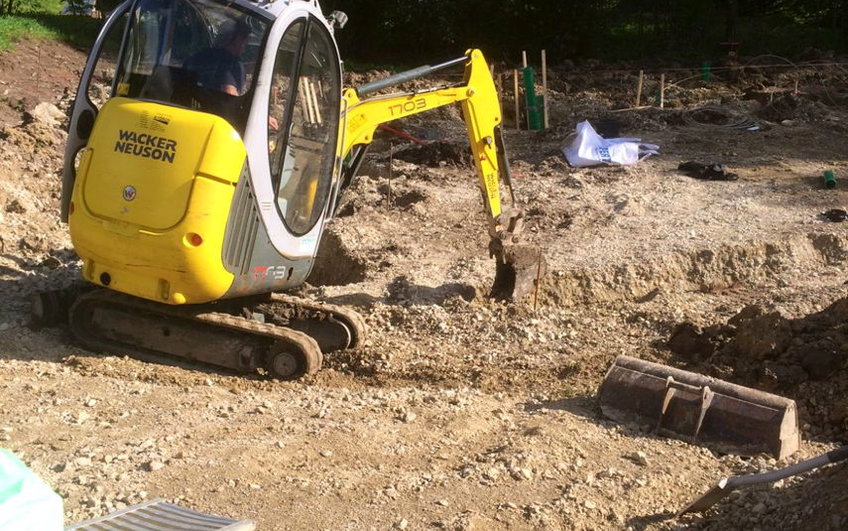 Mini-Bagger beim Ausheben von Gräben für das Streifenfundament.