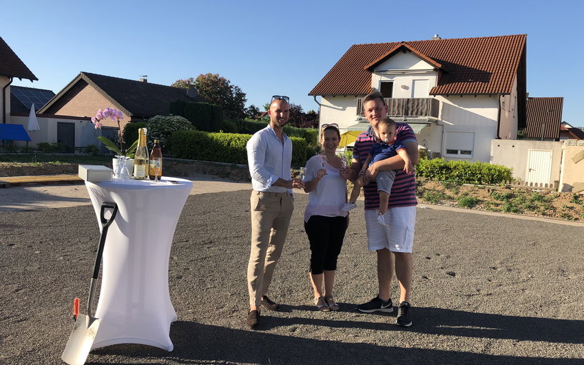 Baufamilie mit Verkaufsberater Bernd Laatz bei der Grundsteinlegung für das frei geplante Einfamilienhaus von Kern-Haus in Römerberg
