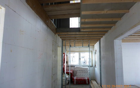 Betondecke mit Treppenloch im Flur mit Holzlattung.