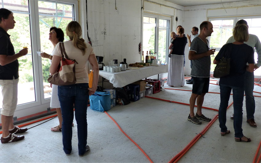 Besucher und Buffet im Wohn- und Essbereich bei der Rohbaubesichtigung im frei geplanten Einfamilienhaus von Kern-Haus in Bad Dürkheim
