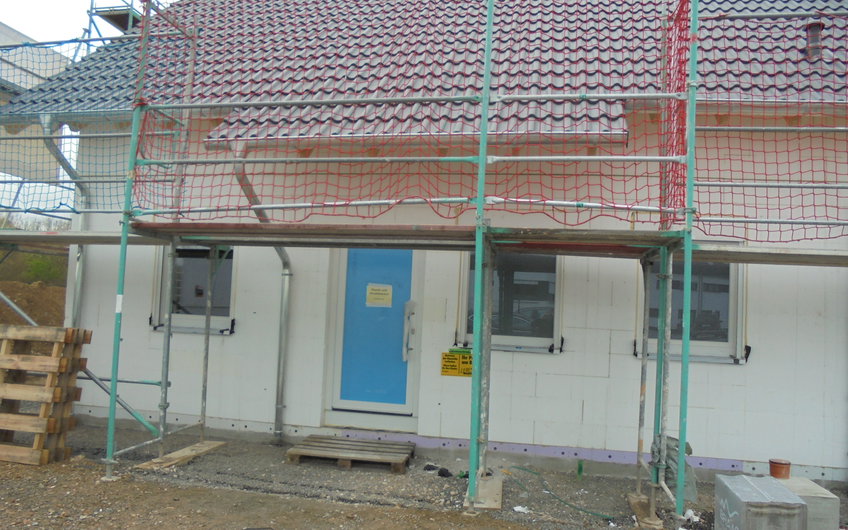 Eingangsseite des Rohbaus des individuell geplanten Einfamilienhauses Luna von Kern-Haus in Ludwigshafen mit eingebauten Fenstern und Tür