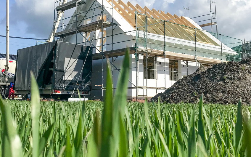 Dachstuhl mit Schalung des Kern-Haus in Halle Reide vom Feld aus gesehen