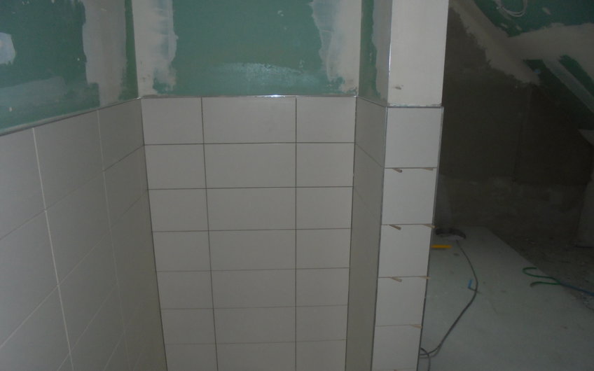 Laufende Fliesenleger-Arbeiten im Badezimmer des individuell geplanten Einfamilienhauses Aura von Kern-Haus in Wachenheim