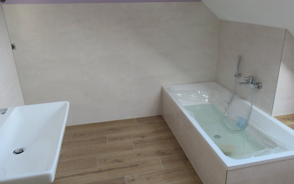Verschiedene Materialien harmonieren im Badezimmer.