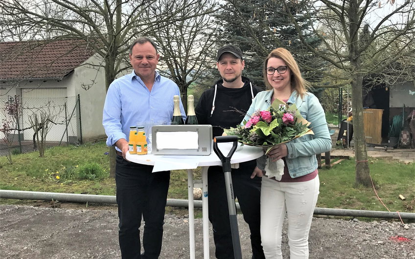 Die Bauherren gemeinsam mit Verkaufsberater Bernhard Spurzem bei der Grundsteinlegung.