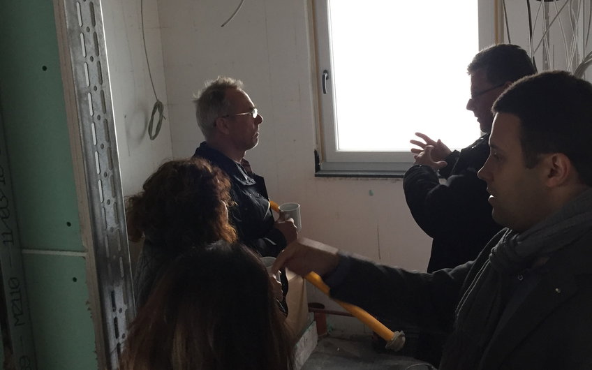 Bauleiter mit interessierten Gästen im Gespräch beim Rohbaufest im individuell geplanten Einfamilienhaus Luna von Kern-Haus in Ludwigshafen