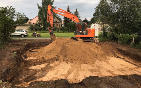 Die Baugrube wird mit einer Sandschicht ausgefüllt.