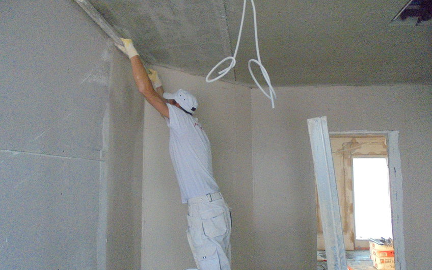 Handwerker beim Verputzen der Wände im individuell geplanten Einfamilienhaus Luna von Kern-Haus in Ludwigshafen
