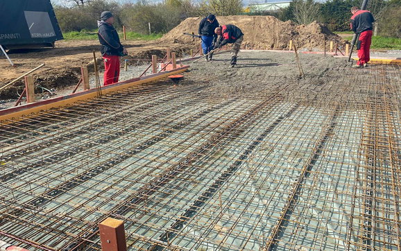 Gießen des Beton in armierte Bodenplatte für Kern-Haus Allea in Eilenburg