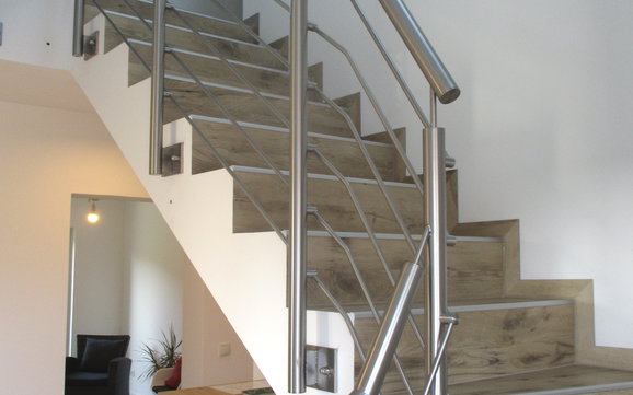 Auf der Betontreppe wurde entsprechend in Holzoptik der gewünschte Treppenbelag angebracht. 