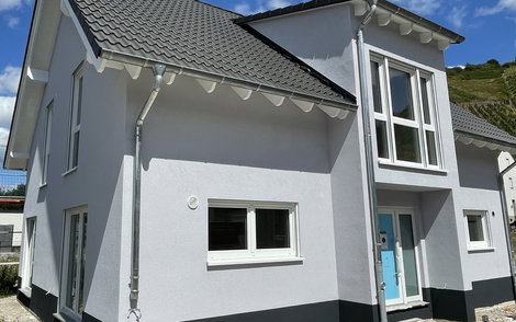 Der Außenputz wurde angebracht und lässt das Kern-Haus im Sonnenlicht erstrahlen.