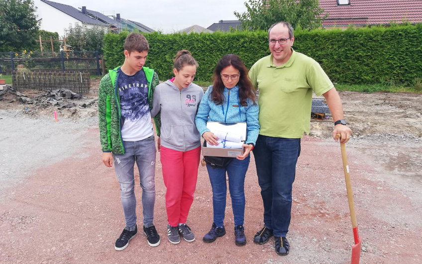 Bauherrenfamilie mit Grundsteinkassette bei Grundsteinlegung für Kern-HAus in Halle Wörmlitz