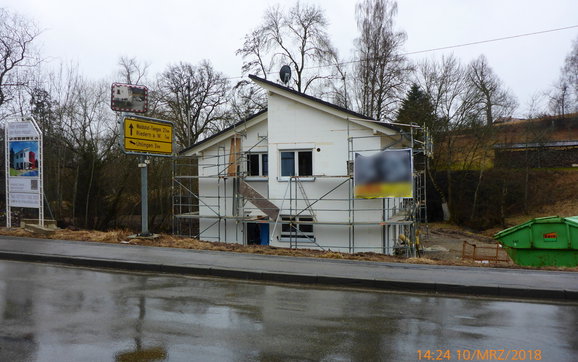 Hausansicht mit tiefer gelegener Eingangsfront.