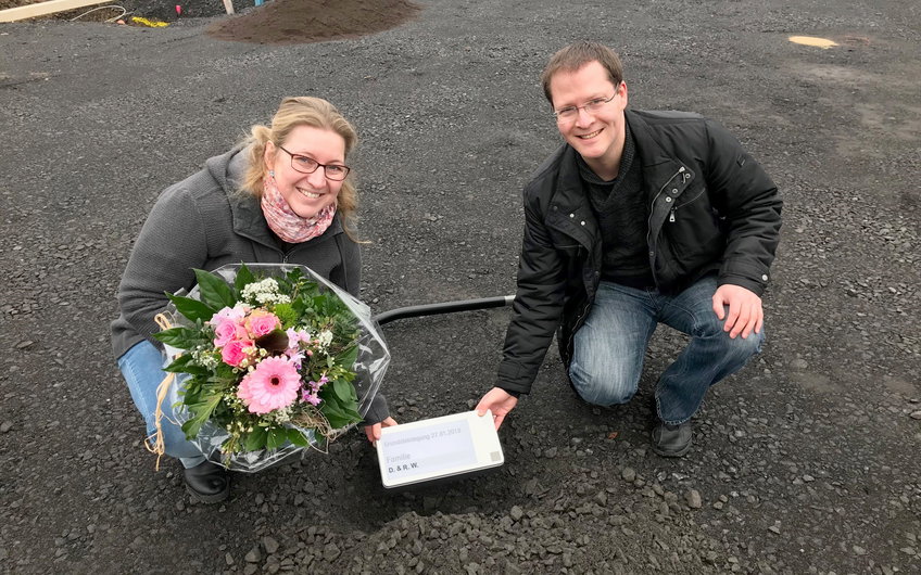 Die Bauherren legen den Grundstein gemeinsam in die Grube.