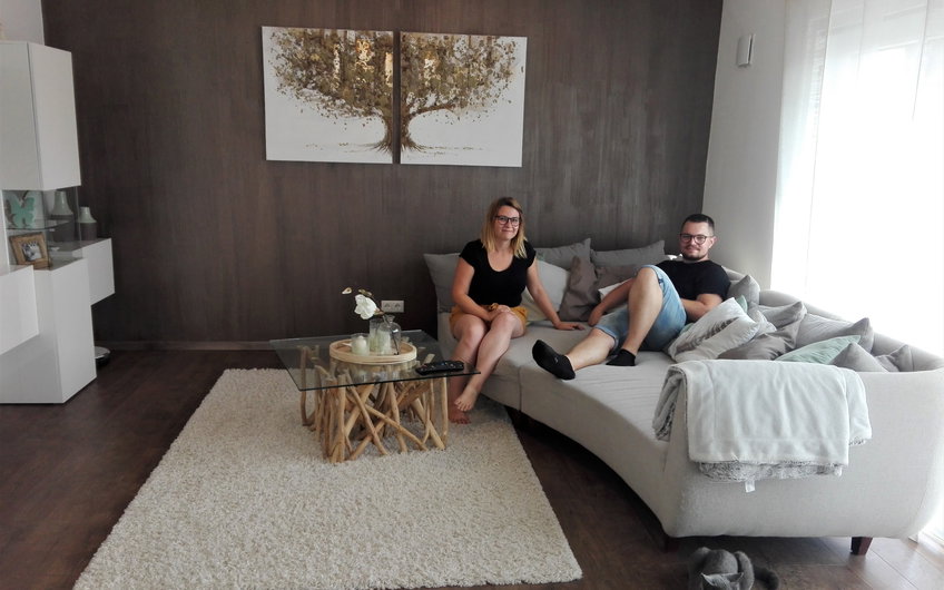 Bauherren auf der Couch im Wohnzimmer des individuell geplanten Einfamilienhauses Signum von Kern-Haus in Einselthum