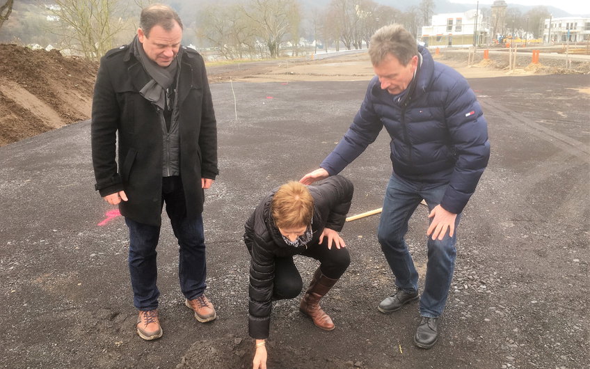 Der Grundstein wird in die Grube gelegt.