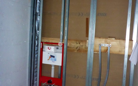 Einseitig offenes Ständerwerk mit WC-Anschlusselement und Leitungen für die Dusche.