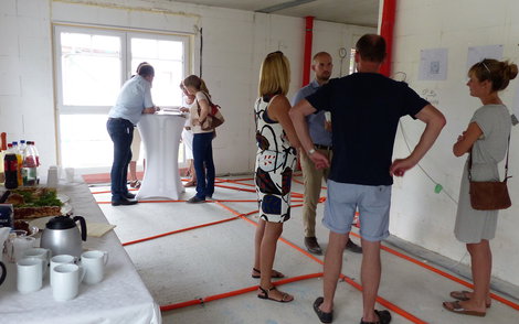 Verkaufsberater im Gespräch mit Interessenten bei der Rohbaubesichtigung im frei geplanten Einfamilienhaus von Kern-Haus in Bad Dürkheim