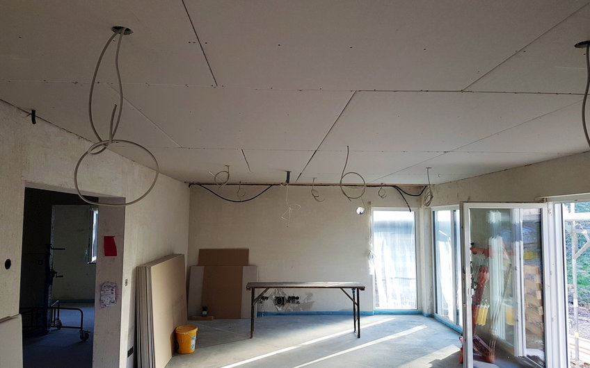 Wohnbereich mit Decke aus Gips-Karton-Platten und sichtbaren Elektroleitungen.