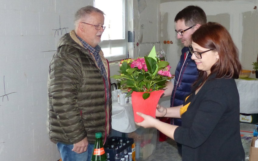 Bauherrin nimmt Blumen von Gast auf dem Rohbaufest in Einselthum entgegen.