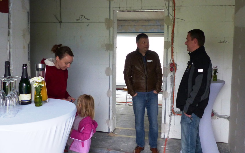 Verkaufsberater Bernd Vogt mit Interessenten im Eingangsbereich des Familienhauses Signum in Einselthum