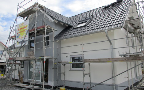 Das Haus wird von außen verputzt.