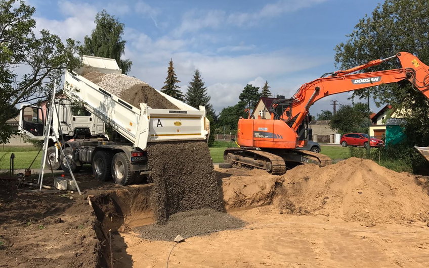 Einbringen der Kies-Schicht in den Bodenplattenunterbau.