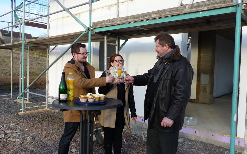 Bauherren und Udo Klosterhalfen stoßen bei der Grundsteinlegung für das individuell geplante Familienhaus Signum von Kern-Haus in Einselthum an.