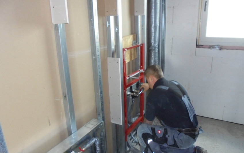 Sanitärinstallateur bei der Arbeit im individuell geplanten Einfamilienhaus Luna von Kern-Haus in Ludwigshafen